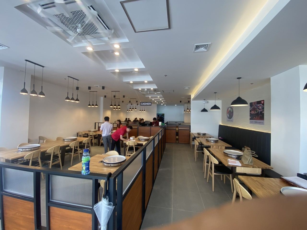 닭갈비 매장 내부. 칸막이 옆으로 원목 테이블과 의자가 줄지어 놓인 모습