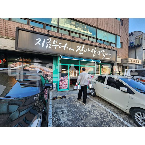 지금부터가진짜삼겹살이다 매장 앞, 간판 아래로 집기를 옮기는 모습